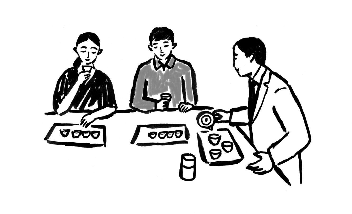 カウンターでスタッフの説明を聞きながらお茶を試飲するお客さま